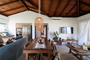 莫罗圣保罗Orixás Residence的厨房以及带木桌的用餐室。