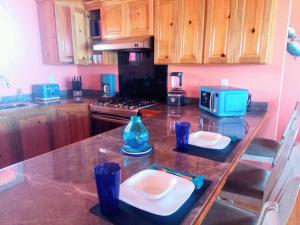 乌蒂拉Casa Corazon Striking Beach Home的厨房配有带盘子和微波炉的桌子