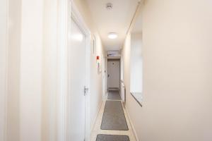 曼彻斯特Airstaybnb的一条带白色墙壁和长走廊的走廊