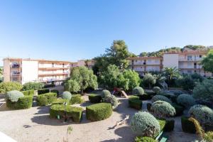 塔拉戈纳Privilegiado-Tarragona-50mPlaya-WIFI-Pool-Relax8的一座花园,在一座建筑前有灌木丛和树木