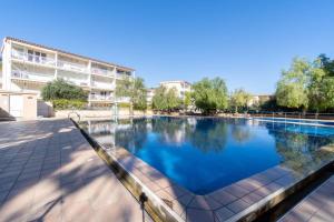 塔拉戈纳Privilegiado-Tarragona-50mPlaya-WIFI-Pool-Relax8的大楼前的蓝色海水大型游泳池