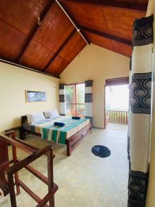 代尼耶耶Rainforest Nature House的一间卧室设有一张床和一个大窗户