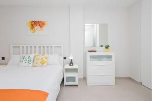 大加那利岛拉斯帕尔马斯Coqueto apartamento cerca playa的白色卧室配有床和白色橱柜