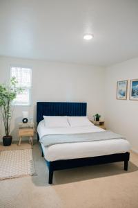 盐湖城Monthly Rate Special - Heart of SLC的一间卧室配有一张大床和蓝色床头板