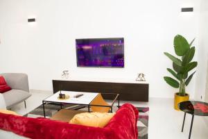 科托努Luxueux Appartement meublé à Cotonou的客厅配有红色沙发和电视