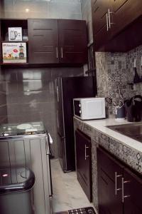 科托努Luxueux Appartement meublé à Cotonou的厨房配有水槽和微波炉