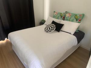 Yandina扬迪纳大篷车公园露营旅馆的卧室内的一张带白色床单和枕头的床