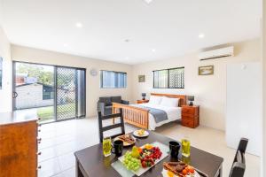 尼尔森湾14A Grafton St - Pet friendly air con studio for a couples retreat的一间房间,配有一张床和一张桌子,上面有食物