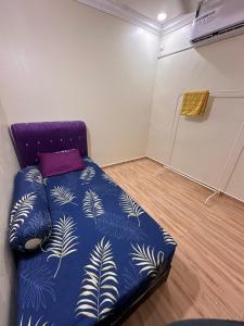 巴西古当Kak Ani Homestay的一间卧室配有一张带蓝色棉被的床