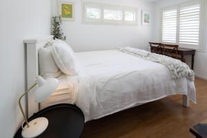 纳尔逊Seymour Sleeps的白色卧室配有白色的床和灯