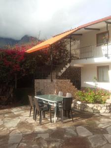 乌鲁班巴Casa de Mama Valle - Urubamba的房子前面的一张桌子和椅子