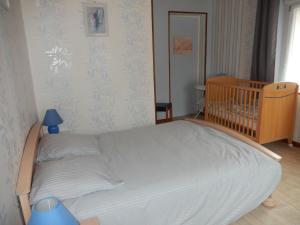 科尔尼蒙Gîte Cornimont, 3 pièces, 5 personnes - FR-1-589-70的一张位于一个房间里的床,一个房间里设有一张婴儿床