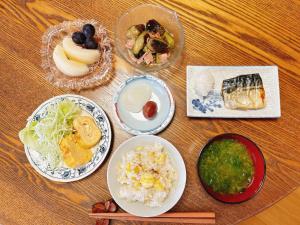 WakamatsuGuest House Island的餐桌,盘子上放着食物和碗