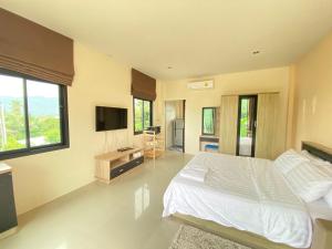 查汶Cozy Apartment Chaweng Center的卧室配有白色的床和电视。