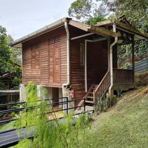 PedasD'Bukit Forest的一座小木房子,位于山丘上,设有门廊