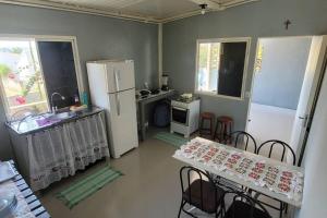 沙帕达-杜斯吉马朗伊斯Casa Dom Aquino的厨房配有2张桌子和白色冰箱