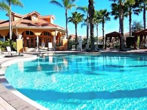 达文波特Family Friendly Home, South-facing Pool,Spa, Gated Resort near Disney -928的棕榈树屋前的大型游泳池