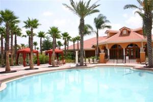 达文波特Family Friendly Home, South-facing Pool,Spa, Gated Resort near Disney -928的一座棕榈树游泳池和一座建筑