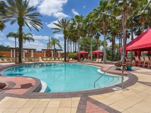 达文波特Family Friendly Home, South-facing Pool,Spa, Gated Resort near Disney -928的度假村内一座种有棕榈树的大型游泳池