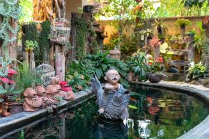清迈@清迈酒店- SHA Extra Plus的花园,花园内有池塘,有一组雕像