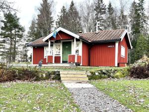 EckerudHoliday home PRÄSSEBO II的院子里有一道带绿门的红色房子