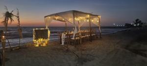 托卢cabañas Juakianna的海滩上的帐篷,配有桌椅