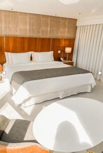 里约热内卢Hotel Nacional RJ - Vista Mar的卧室配有一张白色的大床和一张桌子