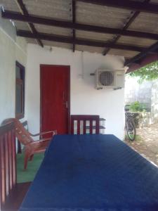 阿努拉德普勒Meera Homestay的一间设有蓝色桌子和红色门的房间