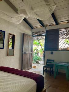 兹波利特Posada Mexico的一间卧室配有一张床、一张桌子和一个窗户。
