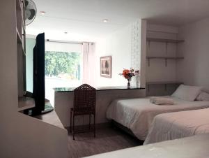 利马Monterrico Suites Hotel的一间卧室设有两张床、一张桌子和一个窗口。