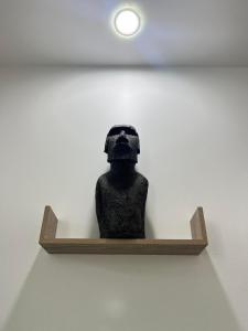 Outu MaoroSerenity Lodge Tahiti Fare Haumana的雕像坐在墙上的架子上