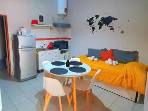 门多萨APART CENTRO RIOJA, Zona Residencial, Parking privado gratis a 100 mts的厨房配有桌子,墙上配有一张带地图的床。