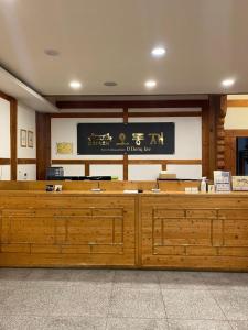 丽水市Korea Traditional Hotel O Dong Jae的大型审判室,配有木桌和墙上的标志