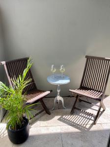 悉尼Seaside Escape的两张椅子和一张桌子及两杯酒杯