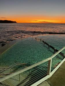 悉尼Seaside Escape的日落时分水中的一个热水浴池