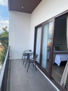 普禾加多44 Guest House Syariah的阳台配有桌椅和1张床。