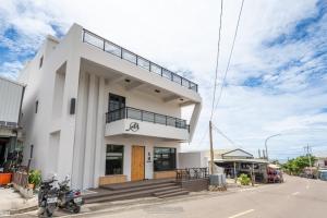 小琉球岛觅曙  的一座白色的建筑,前面停有一辆摩托车