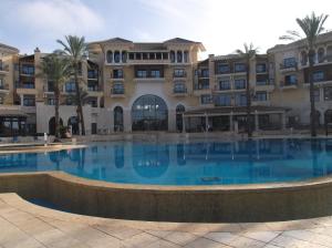 托雷帕切科Superb luxurious groundfloor 1 bedroom app on Mar Menor golf resort的大楼前的大型游泳池