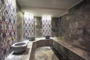 加济安泰普乌古鲁酒店的带浴缸的浴室和彩色玻璃窗