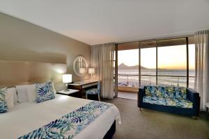 开普敦泻湖滩酒店及Spa的酒店客房设有一张床、一张书桌和窗户。