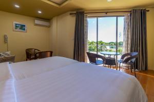 科卢马杜卢Blue Wave Hotel Maldives for SURF, FISHING and Beach的卧室配有白色的床和桌椅