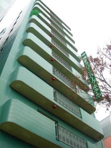 青森Aomori Green Park Hotel的一座高大的建筑,旁边有一个标志