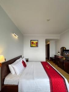 龙川市Đông Xuyên Hotel的卧室配有一张大白色床和红色毯子