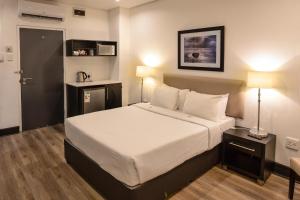 德班潘若迪酒店的一间卧室配有一张带白色床单的大床
