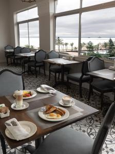 德班潘若迪酒店的用餐室配有桌椅,提供早餐食品