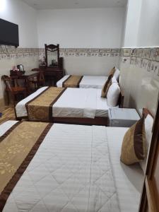 Ấp Trà KhaSơn Tùng Motel的一间卧室配有两张床和一张桌子