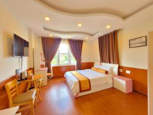 大叻Villa H Flower Đà Lạt的配有一张床和一张书桌的酒店客房