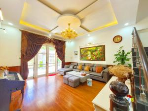 大叻Villa H Flower Đà Lạt的客厅配有沙发和桌子