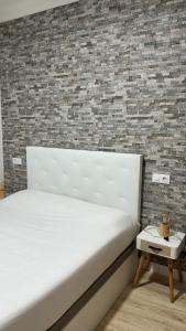 维戈Bouzasol的卧室配有白色的床和砖墙