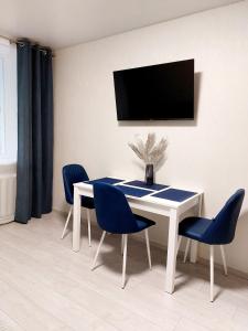 赫梅利尼茨基Свежая 2-комнатная квартира в центре的一间配备有白色桌子和蓝色椅子的用餐室
